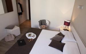 ミラノにあるホテル メンニーニのベッドルーム1室(白いベッド1台、ケーキ付)