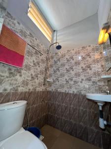 a bathroom with a toilet and a sink at DG Hôtel in Cotonou