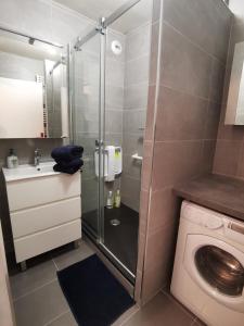 a bathroom with a shower and a washing machine at Proche Disney, gare RER A et lac in Torcy