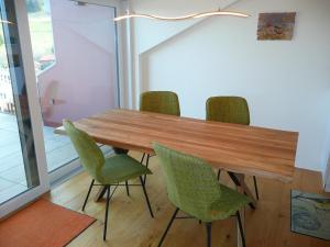 a dining room table with green chairs and a light fixture at NEU! Ferienwohnung mit Dampfdusche in Wertach