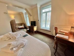 een slaapkamer met een bed, een bureau en een raam bij Logis Hôtel Le Rivage in Gien