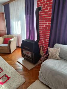 a living room with a wood stove in a room at Villa Artemida apartman in Kulen Vakuf