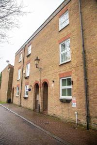 a brick building with two windows on a street at Cosy and Spacious House for 6 in Rochester