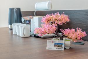 a table with flowers in vases on a desk at Motel "Płomyk" blisko Słubice in Kunowice