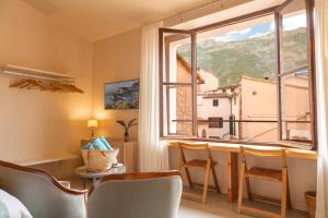 um quarto com uma mesa e cadeiras e uma grande janela em SólleRooms em Sóller