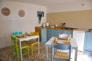 a kitchen with blue cabinets and tables and chairs at Casa Dona' Penne in Penne
