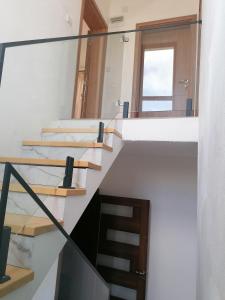 a staircase in a house with a glass railing at Pelister Riverside Villa in Bitola
