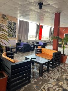 una habitación con sofás y mesas en un edificio en DG Hôtel en Cotonú
