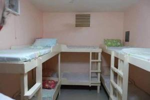 a room with three bunk beds in it at New Village Lodge in Oslob