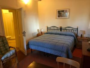 a bedroom with a bed with a blue comforter and a chair at CasaLeTolfe Residence in Siena