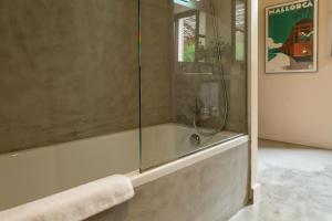 een douche met een glazen deur in de badkamer bij SólleRooms in Sóller