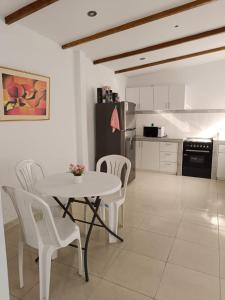 cocina con mesa y sillas y cocina con nevera en Casa Las Lomas Huanchaco-Trujillo Piscina, en Huanchaco