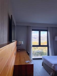 a hotel room with a bed and a large window at Montanyà in Seva