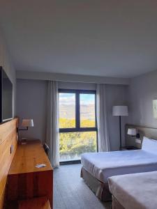 a hotel room with two beds and a large window at Montanyà in Seva