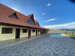 uma imagem de uma casa com piscina em Rancho Chega Mais 3 em Carmo do Rio Claro