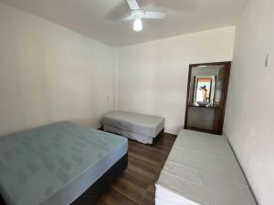 ein kleines Schlafzimmer mit 2 Betten und einem Spiegel in der Unterkunft Rancho Chega Mais 3 in Carmo do Rio Claro