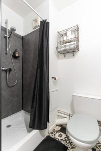 y baño con aseo blanco y ducha. en Studio Centre-Ville avec Terrasse et Parking Sécurisé Gratuit, en Nantes