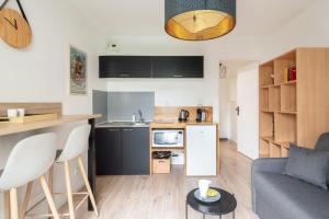 cocina y sala de estar con sofá y mesa en Studio Centre-Ville avec Terrasse et Parking Sécurisé Gratuit, en Nantes