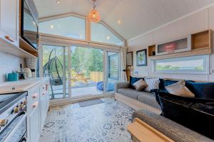 a living room with a couch and a large window at Hillside Cabin in Caersws