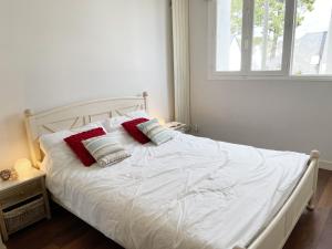 カルナックにあるKermario 1, bel appartement à Carnac, Wifi inclusの白いベッド(枕2つ付)が備わるベッドルームです。