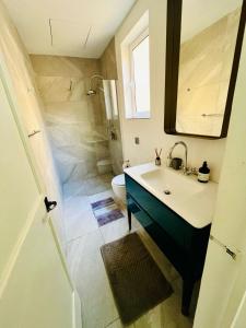 La salle de bains est pourvue d'un lavabo, de toilettes et d'un miroir. dans l'établissement Cozy Charming Apartment in Old Bakery Street, à La Valette