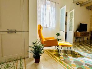 un salon avec une chaise jaune et une table dans l'établissement Cozy Charming Apartment in Old Bakery Street, à La Valette