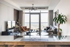 a living room with a table and a large window at Chic One Bedroom Apartment with Full Sea View in Dubai