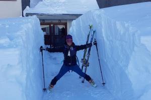 una persona está de pie en la nieve con esquís en Alojamiento 3Mara en San Isidro