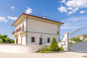 Cette petite maison blanche dispose d'un balcon et d'une clôture. dans l'établissement TENUTA FOGLIANI, à Visciano