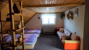 a attic room with two bunk beds and a couch at Chata Marta in Liptovské Kľačany