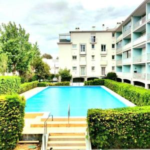 uma grande piscina em frente a um edifício em Front de Mer et Grande Piscine pour un appartement chic et cosy, appartement en résidence à Canet en Roussillon, à 10 minutes de Perpignan em Canet-en-Roussillon