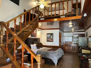 1 dormitorio con 1 cama y escalera de madera en Captain Morgan's Retreat, en San Pedro