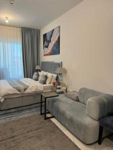 een grote slaapkamer met een bed en een bank bij Beautiful Cozy Studio (Masdar City) in Al Qurayyah