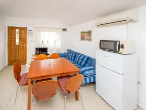 a kitchen and living room with a table and a couch at Apartment Jadria near the beach in Šibenik