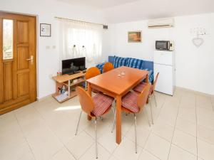 a kitchen and dining room with a wooden table and chairs at Apartment Jadria near the beach in Šibenik