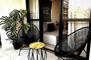 2 sillas y una mesa en un balcón con sofá en Barra Corinto 300 Parque Olímpico Rio centro, en Río de Janeiro