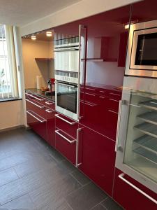 a kitchen with red cabinets and an oven at APARTMENT PETER in Interlaken
