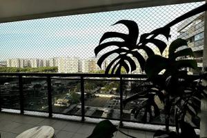 una ventana con vistas a la ciudad y una planta en Barra Corinto 300 Parque Olímpico Rio centro, en Río de Janeiro