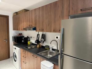 a kitchen with a stainless steel refrigerator and a sink at Beautiful Cozy Studio (Masdar City) in Al Qurayyah