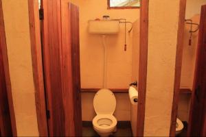 a small bathroom with a toilet in a stall at Explorers River Camp in Jinja