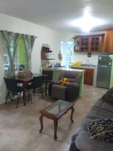 a living room with a couch and a table and a kitchen at Mountain View, Jacks Hill in Kingston