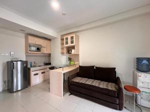 ein Wohnzimmer mit einem Sofa und einer Küche in der Unterkunft Comfy Rooms at Parahyangan in Bandung
