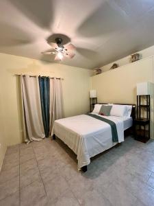 a bedroom with a bed and a ceiling fan at Sea-Renity Hideaway (Studio Apt) in Woods