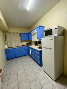 a kitchen with blue cabinets and a white refrigerator at Sea-Renity Hideaway (Studio Apt) in Woods