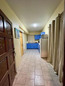 a hallway of a kitchen with a refrigerator and a door at Sea-Renity Hideaway (Studio Apt) in Woods