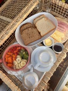 una bandeja de comida con pan y verduras en una mesa en Studios Malakoopa - Praia do Rosa, en Praia do Rosa