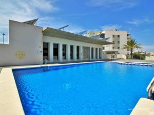 una gran piscina azul junto a un edificio en Modern Airy 2-bedroom Los Dolses Villamartin, en Los Dolses