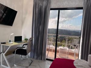 a room with a desk with a computer and a balcony at Villa Valentina Holidays in Camú