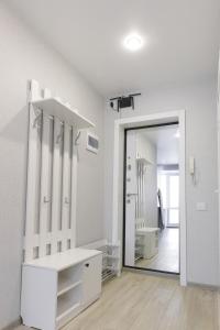 uma sala de vestir com um espelho e uma parede branca em Сomfortable apartment in the central square em Öskemen