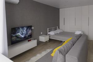 um quarto com uma cama e uma televisão de ecrã plano em Сomfortable apartment in the central square em Öskemen